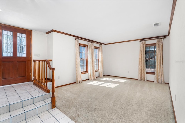 carpeted entrance foyer with crown molding