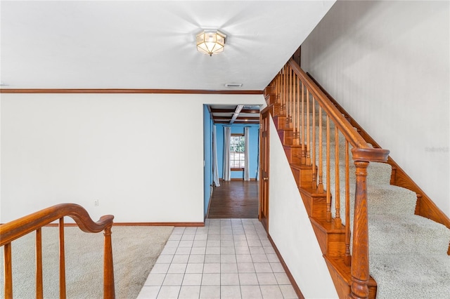 stairway with ornamental molding and tile patterned flooring