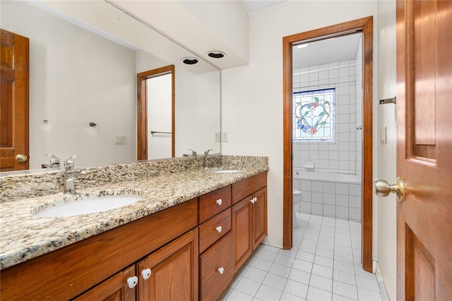 full bathroom with tiled shower / bath combo, vanity, tile patterned floors, and toilet