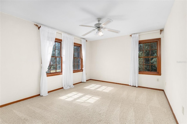 carpeted empty room featuring a wealth of natural light and ceiling fan