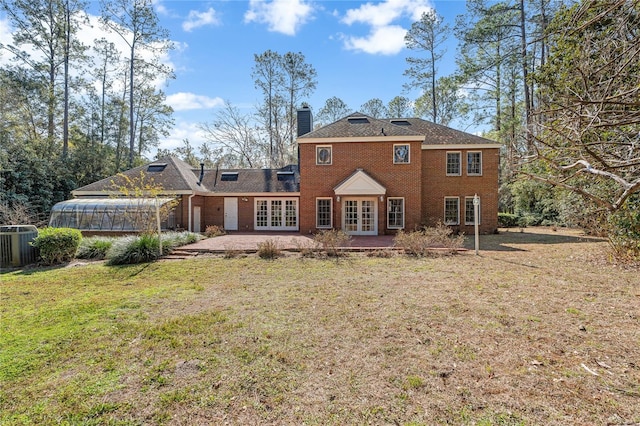 rear view of house featuring french doors, a yard, central AC unit, and a patio area