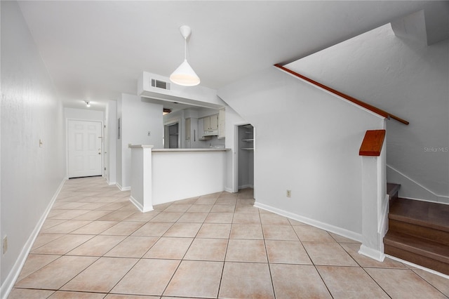 unfurnished living room featuring vaulted ceiling and light tile patterned floors