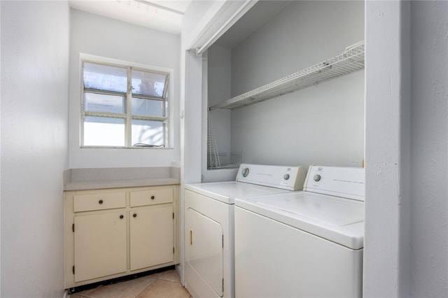 clothes washing area featuring washer and dryer and light tile patterned floors