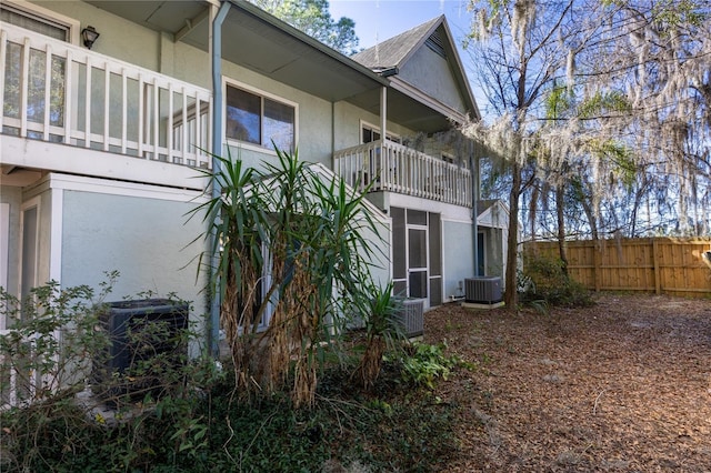 view of side of property featuring cooling unit and a balcony