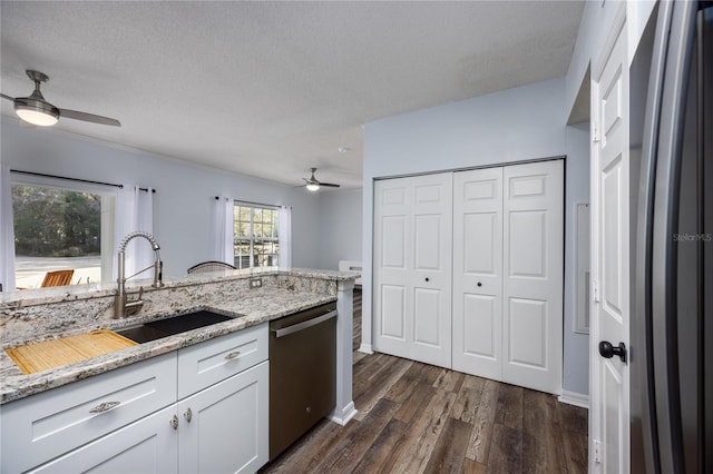 kitchen featuring dishwasher, light stone countertops, sink, and white cabinets