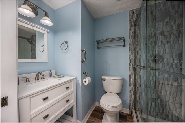 bathroom featuring toilet, an enclosed shower, a textured ceiling, vanity, and hardwood / wood-style flooring