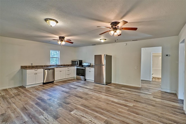 300 S US Highway 129, Bell, FL 32619 - kitchen featuring ceiling fan, appliances with stainless steel finishes, light hardwood / wood-style floors, and white cabinets