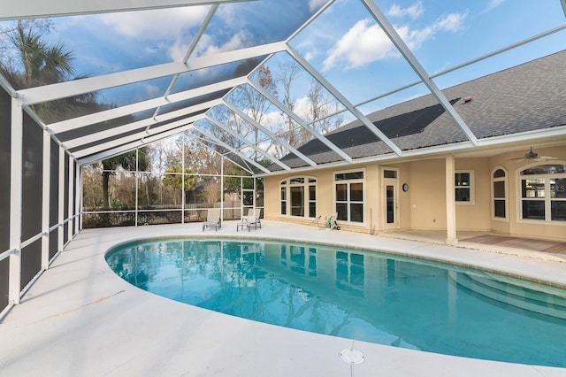 view of pool with ceiling fan, a lanai, and a patio