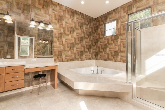 bathroom with tile patterned floors, a healthy amount of sunlight, independent shower and bath, and tile walls