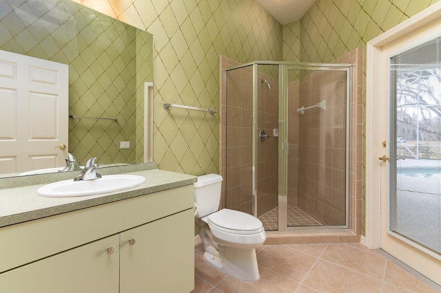 bathroom with vanity, a shower with door, tile patterned floors, and toilet