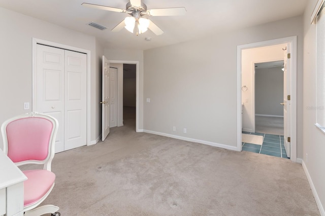 carpeted bedroom with ensuite bath, ceiling fan, and a closet