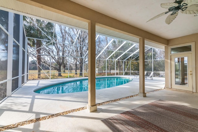 view of swimming pool featuring a patio area, ceiling fan, and glass enclosure