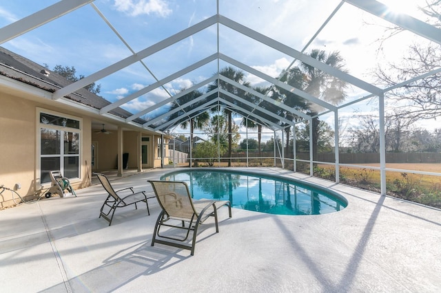 view of pool with ceiling fan, a lanai, and a patio area