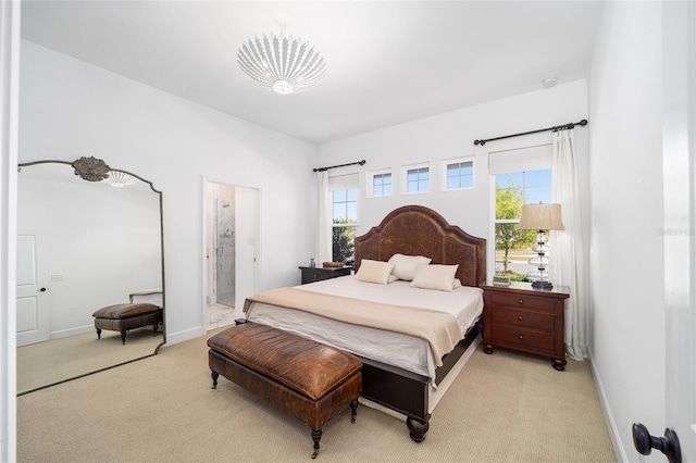 bedroom with light carpet and ensuite bathroom