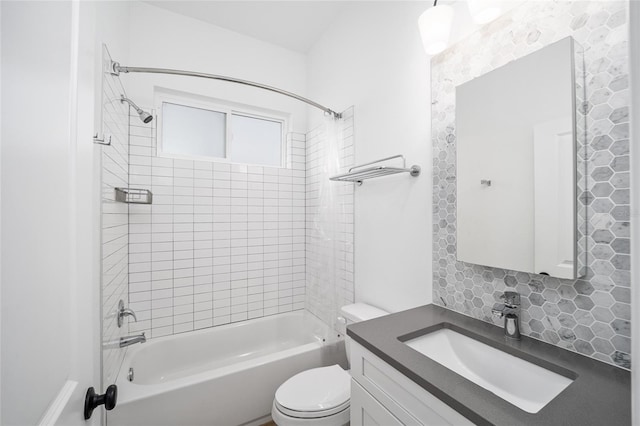 full bathroom featuring tiled shower / bath, vanity, and toilet