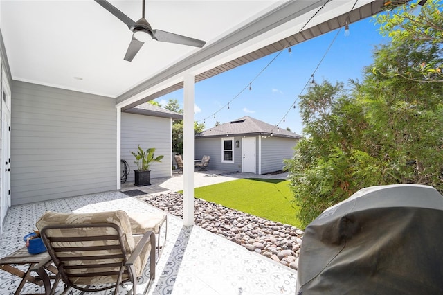 exterior space with a grill, an outbuilding, and ceiling fan