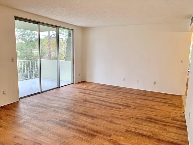 empty room featuring a textured ceiling and light wood-type flooring