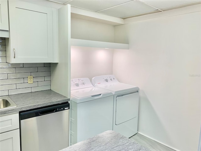 laundry area featuring independent washer and dryer, sink, and light wood-type flooring