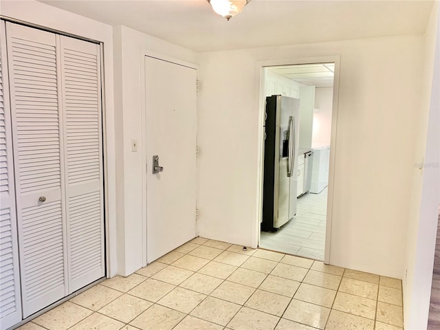 unfurnished bedroom featuring stainless steel refrigerator with ice dispenser and light tile patterned floors