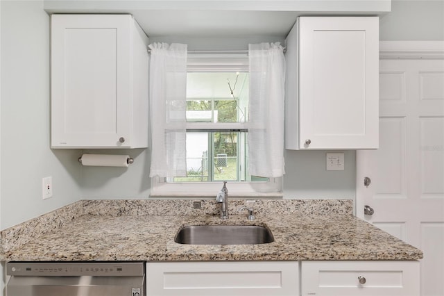 kitchen with dishwasher, light stone countertops, sink, and white cabinets