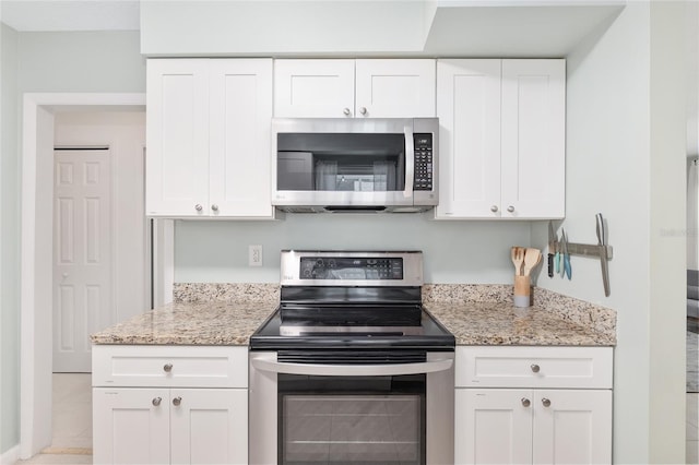 kitchen featuring white cabinetry, appliances with stainless steel finishes, and light stone counters