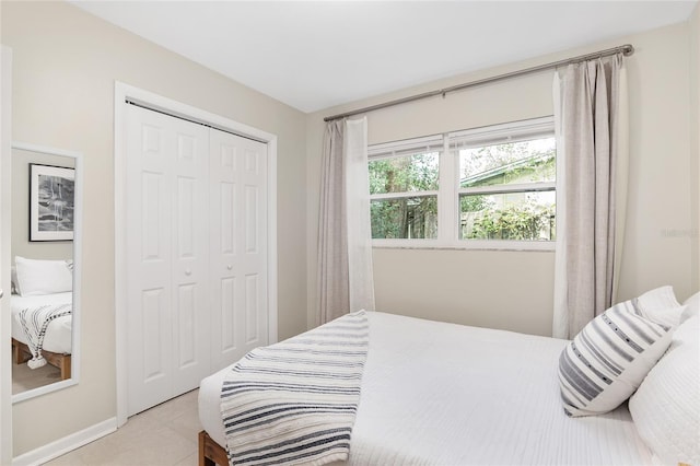 bedroom with light tile patterned floors and a closet