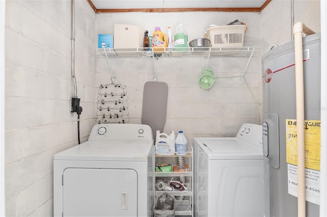 clothes washing area featuring washer and dryer and water heater