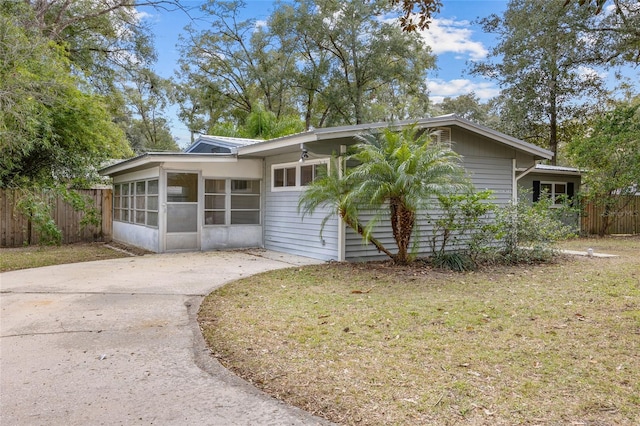 view of front of house featuring a front lawn and a sunroom