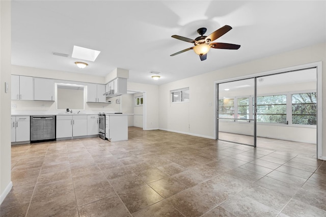 kitchen featuring sink, white cabinetry, a skylight, ceiling fan, and stainless steel appliances