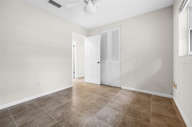 unfurnished bedroom featuring ceiling fan and a closet