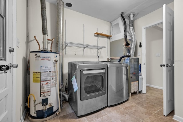 laundry area featuring water heater, light tile patterned flooring, and washer and dryer