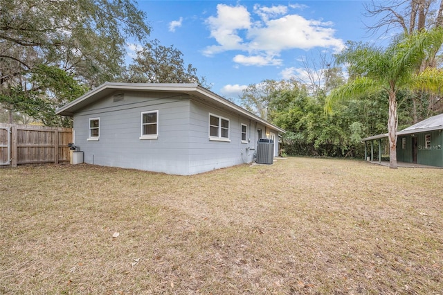 back of house with cooling unit and a yard