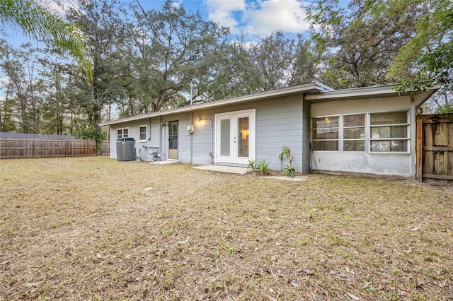 view of front of property featuring central AC, a front lawn, and french doors