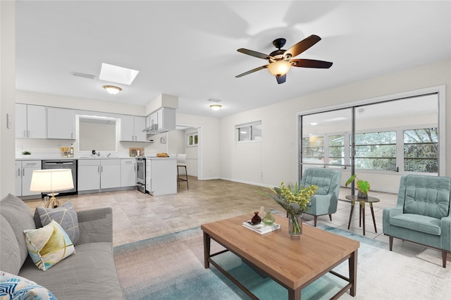 living room featuring sink, a skylight, and ceiling fan