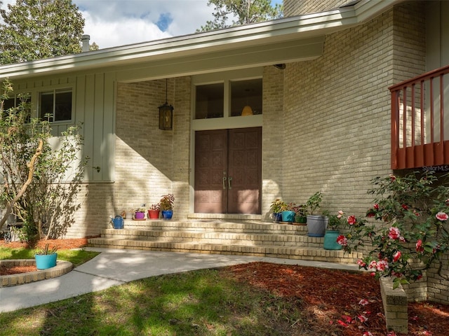 property entrance with covered porch and brick siding