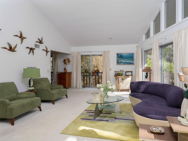 carpeted living area with high vaulted ceiling, plenty of natural light, and visible vents