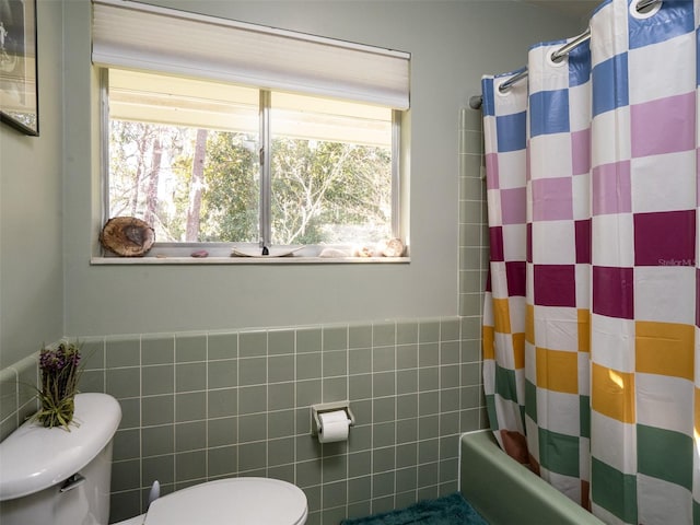 bathroom with shower / tub combo, tile walls, and toilet