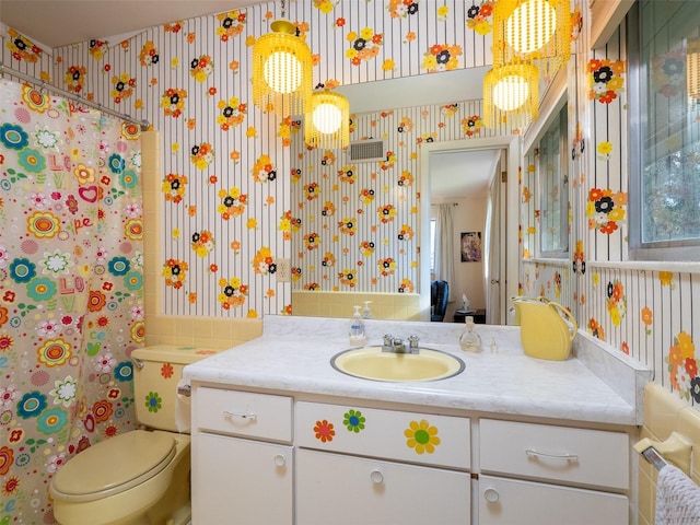 full bath featuring a shower with shower curtain, vanity, toilet, and wallpapered walls