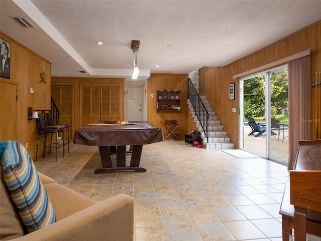 recreation room featuring visible vents, billiards, wooden walls, and a textured ceiling