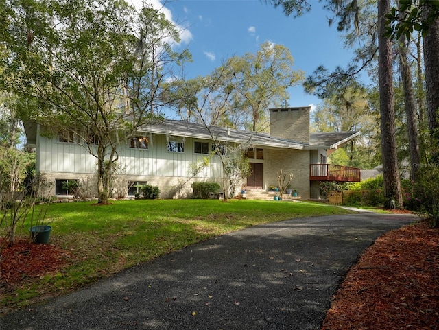 view of front of home with a chimney and a front lawn