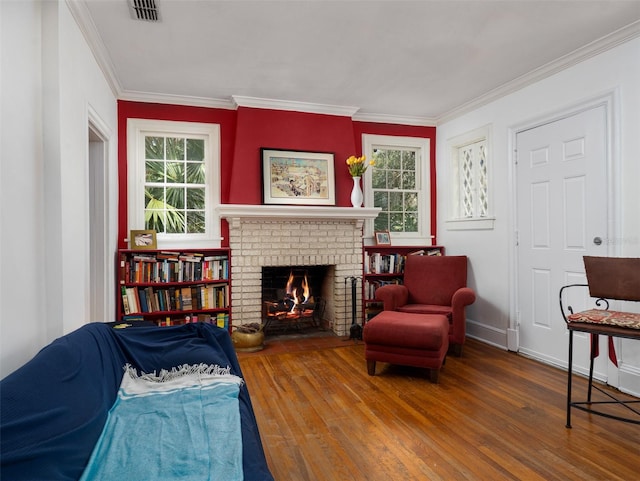 sitting room with visible vents, ornamental molding, a wealth of natural light, and wood finished floors