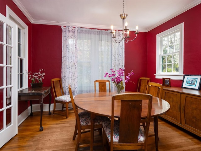 dining space featuring a chandelier, crown molding, baseboard heating, and wood finished floors