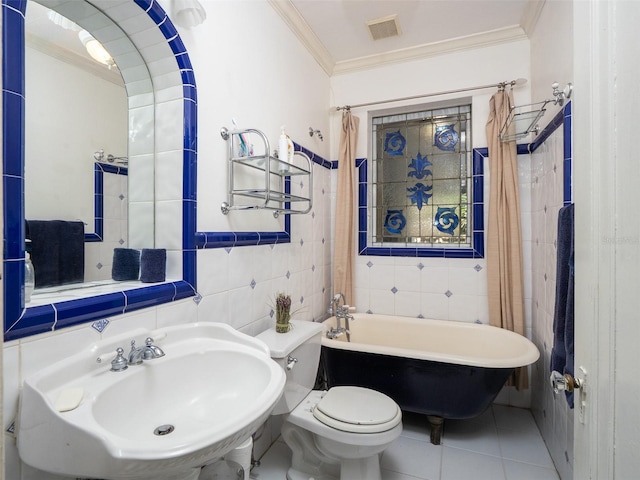 full bathroom with visible vents, tile walls, a tub, crown molding, and a sink