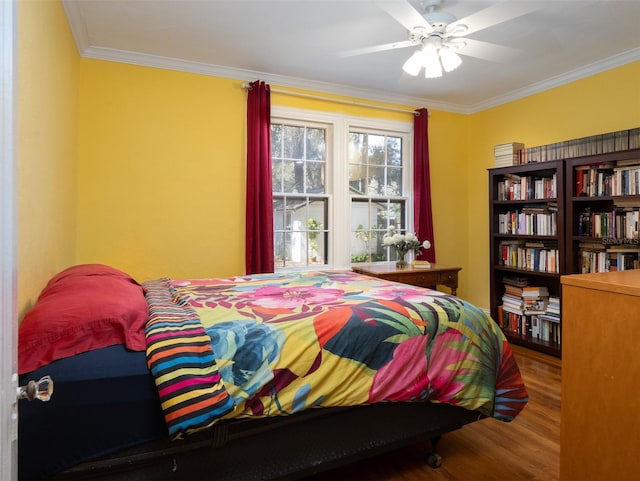 bedroom with ceiling fan, ornamental molding, and wood finished floors