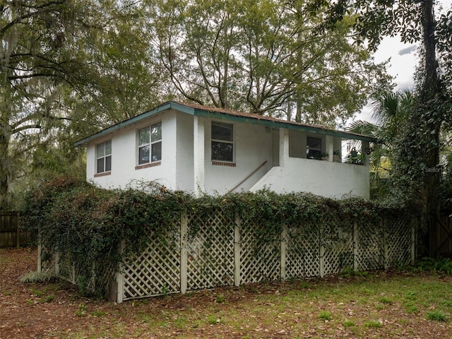 view of property exterior featuring fence and stucco siding