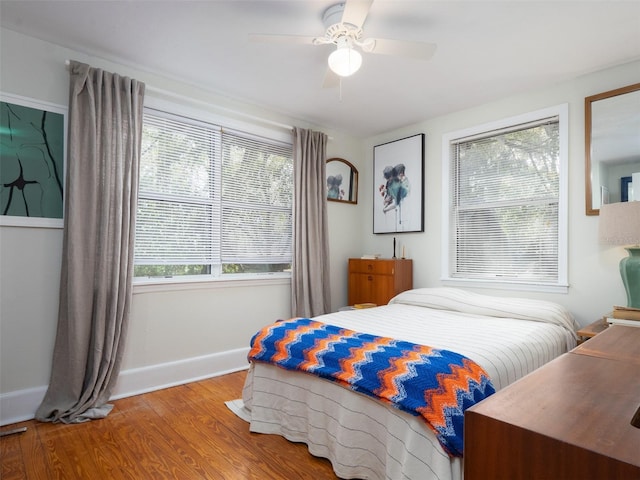 bedroom with wood finished floors, a ceiling fan, and baseboards