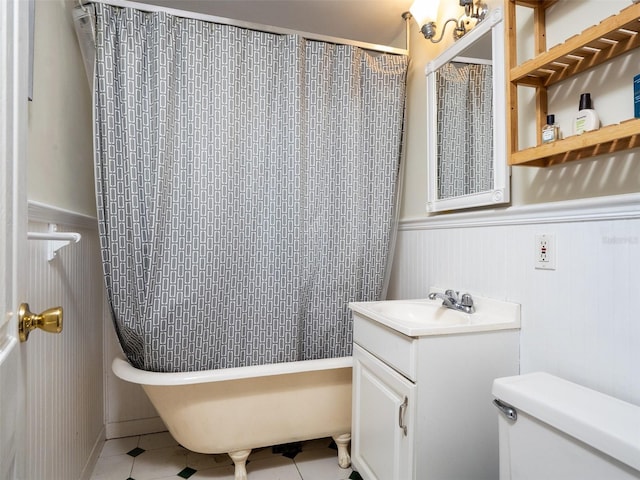 full bathroom featuring a shower with shower curtain, toilet, a wainscoted wall, a tub, and vanity