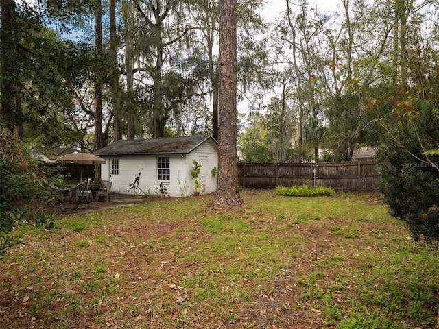 view of yard featuring fence and an outbuilding