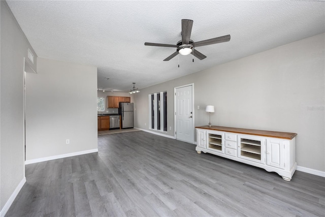 unfurnished living room with ceiling fan, a textured ceiling, and light hardwood / wood-style flooring