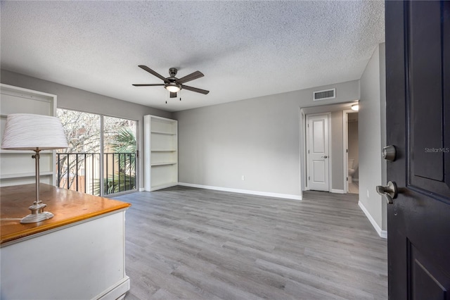 interior space featuring hardwood / wood-style floors, a textured ceiling, and ceiling fan